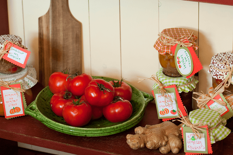 Tomaten op een groen bord met potjes eromheen